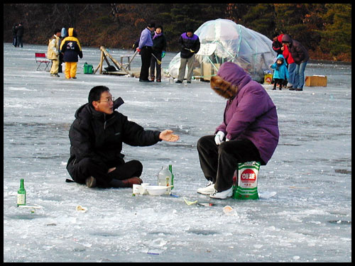 공어를 낚으며 마주앉아 공어회와 소주한잔에 삶의 이야기도 가득. 식용유 깡통을 의자로 활용한 모습이 이색적이다. 